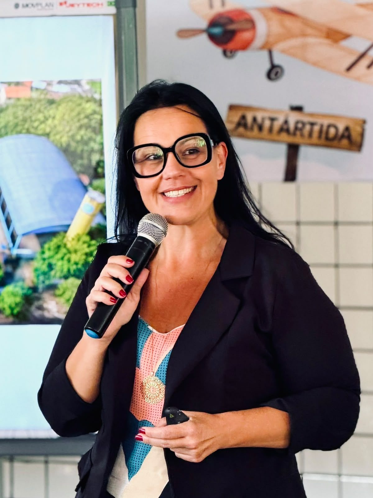 Letícia Semenzato falando ao microfone em evento